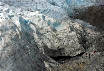 (M. Scott Moon/Peninsula Clarion via AP, File). FILE - In this file photo taken Aug. 7, 2011, hikers get a close look at Exit Glacier near Seward, Alaska. The glaciers' source, the Harding Ice Field, has lost both surface area and depth, which is one e...