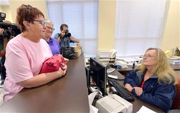 (AP Photo/Timothy D. Easley). Karen Roberts, left, and her partner, April Miller, speak to Assistant Rowan County Clerk Kim Russell as they attempt to get a marriage license at the Rowan County Courthouse in Morehead, Ky., Tuesday, Sept. 1, 2015. Rowan...