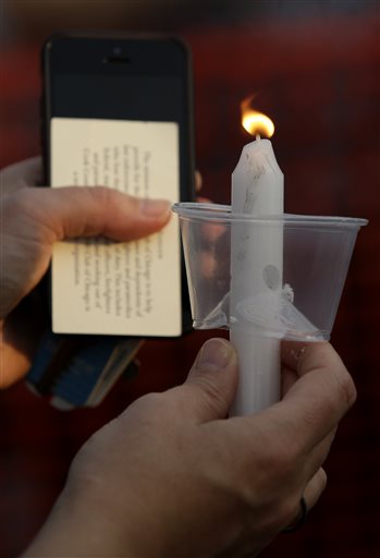(AP Photo/Nam Y. Huh). A mourner holds a candle light during a vigil at Lakefront Park to honor the memory of Fox Lake Police Lt. Charles Joseph Gliniewicz on Wednesday, Sept. 2, 2015, in Fox Lake, Ill. Gliniewicz was shot and killed Tuesday while purs...