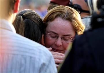 (AP Photo/Nam Y. Huh). Fox Lake Police Lt. Charles Joseph Gliniewicz's wife Mel, right, hugs a mourner during a vigil at Lakefront Park to honor him, Wednesday, Sept. 2, 2015, in Fox Lake, Ill. Gliniewicz was shot and killed Tuesday while pursuing a gr...
