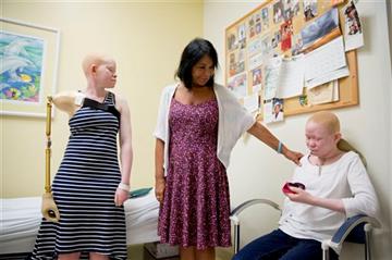 (AP Photo/Matt Rourke). Elissa Montanti, founder and director of the Global Medical Relief Fund, center, places a hand on Pendo Sengerema Noni, right, as Kabula Nkarango Masanja, left, looks on during a prosthetic limb fitting, Tuesday, Aug. 25, 2015, ...