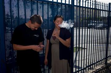 (AP Photo/Jae C. Hong). In this Wednesday, July 29, 2015 photo, drug rehab residents, Kevin Lim, left, 18, and Anny Hong, 32, share an electronic cigarette in the parking lot of Nanoom Christian Fellowship in Los Angeles. Nanoom is a church that double...