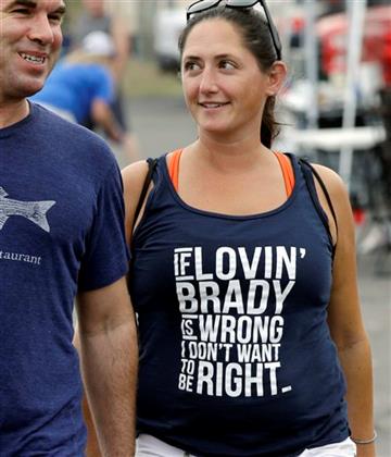 (AP Photo/Stephan Savoia). Kate Lyons wears a shirt referring to Patriots quarterback Tom Brady as she walks with Josh Mailloux before an NFL preseason football game between the Patriots and the New York Giants Thursday, Sept. 3, 2015, in Foxborough, M...
