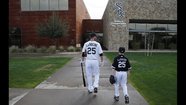 FILE - In this Feb. 28, 2015, file photo, Chicago White Sox's Adam LaRoche, left, and his son Drake walk to the White Sox's clubhouse during a photo day before a baseball spring training workout in Phoenix. Told to cut down his son's time in the clubhouse, LaRoche took a different path: He said he planned to retire and walk away from a $13 million salary. White Sox President Kenny Williams confirmed Wednesday, March 16, 2016, that he twice asked LaRoche in the last week to 